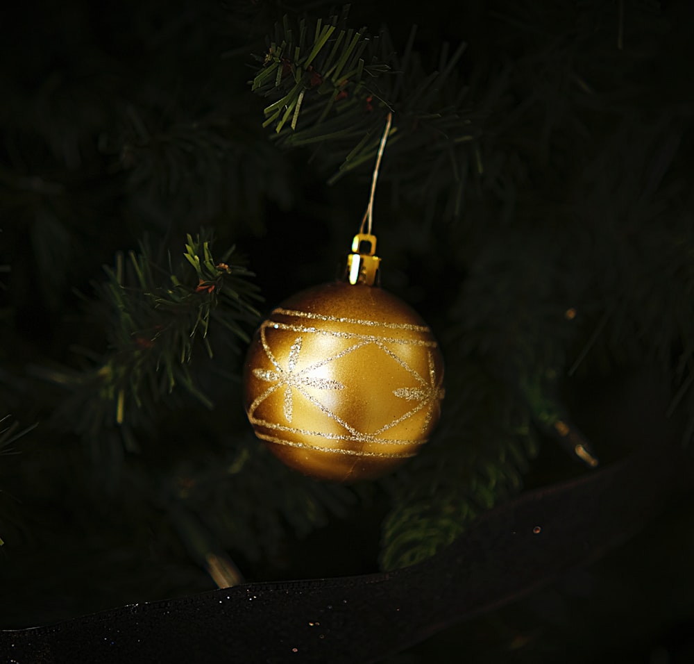 a gold ornament hanging from a christmas tree