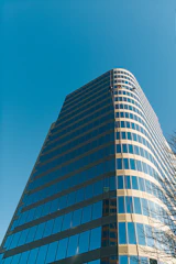 Modern building exterior with workers maintaining facilities under a clear sky.