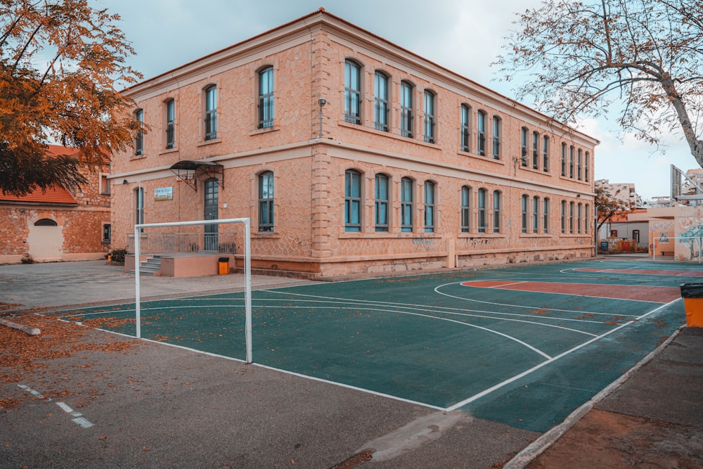 a basketball court in front of a brick building