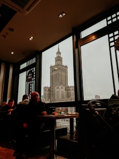 people sitting at a table in front of large windows
