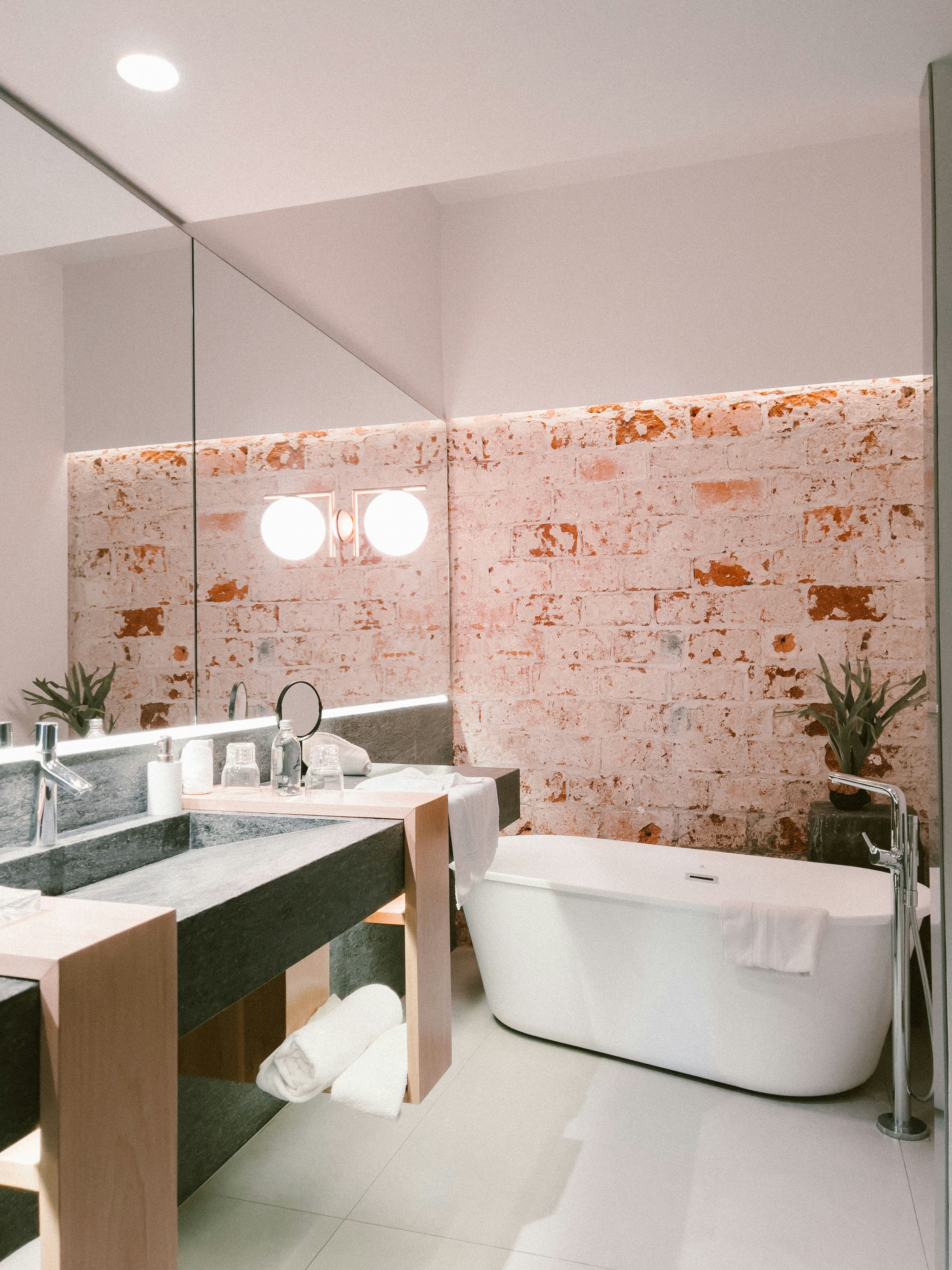 a bathroom with a tub, sink and mirror