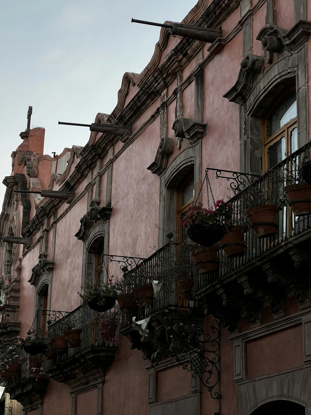 a building with a bunch of planters on the balconies