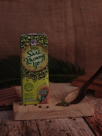 Artistic shot of gurih flavor keripik in natural green packaging with fresh leaves background.