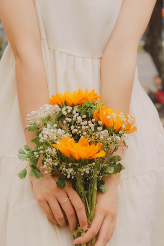 a woman in a white dress holding a bouquet of flowers