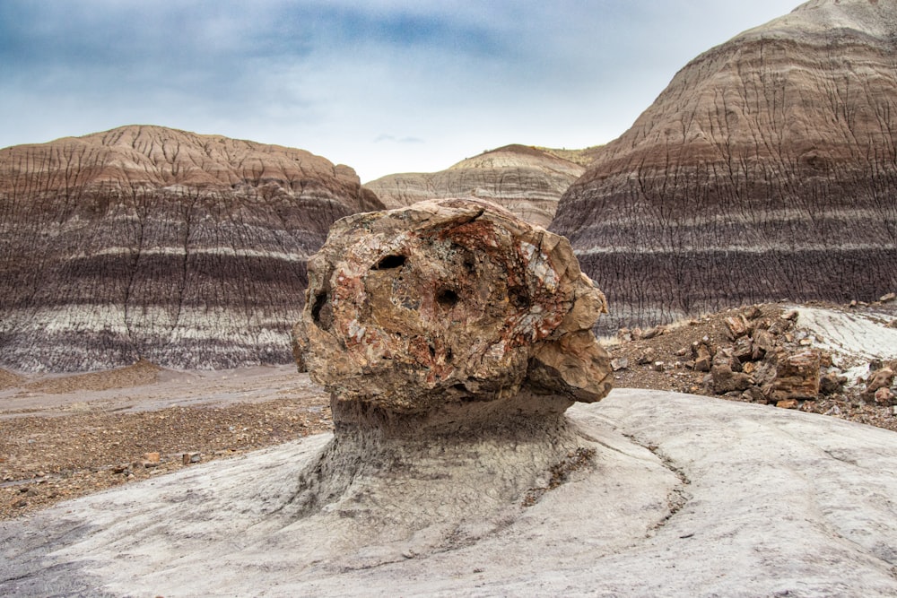 a large rock in the middle of a desert