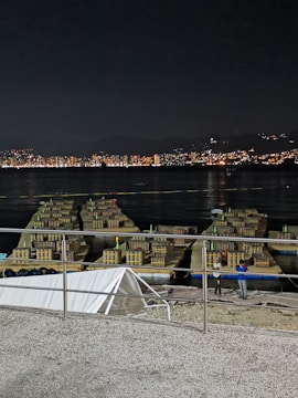 A professional technician in safety gear setting up fireworks equipment at dusk.