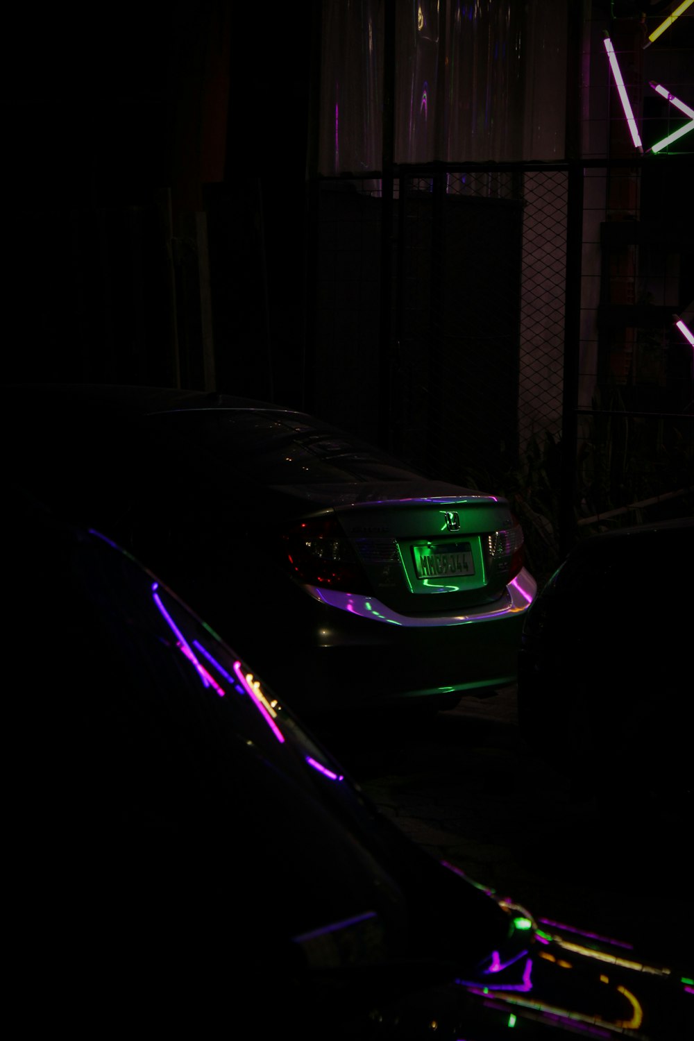 a car is parked in the dark with neon lights