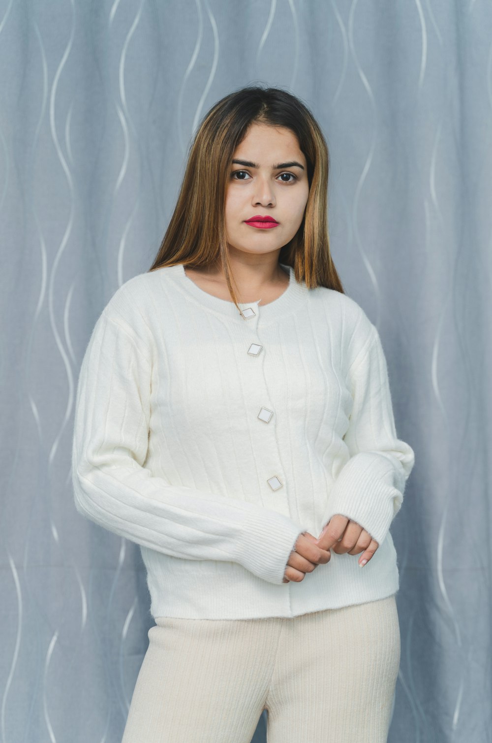 a woman wearing a white sweater and pants