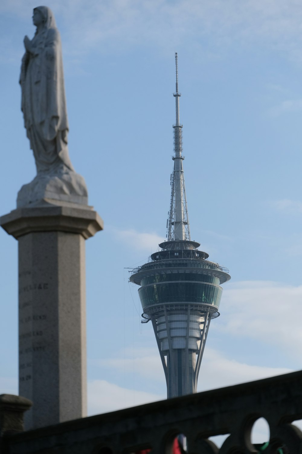 a view of a statue and a tower in the background