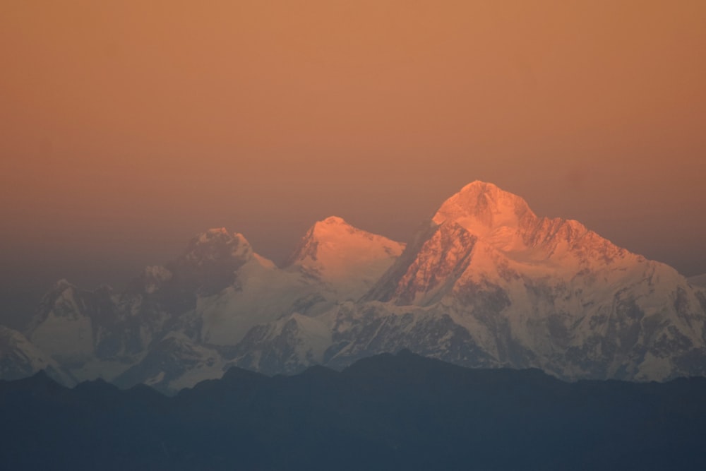 a view of a snow covered mountain at sunset