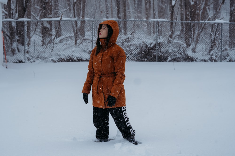 a woman standing in the snow in a park