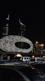 a picture of a city at night with cars parked in front of it