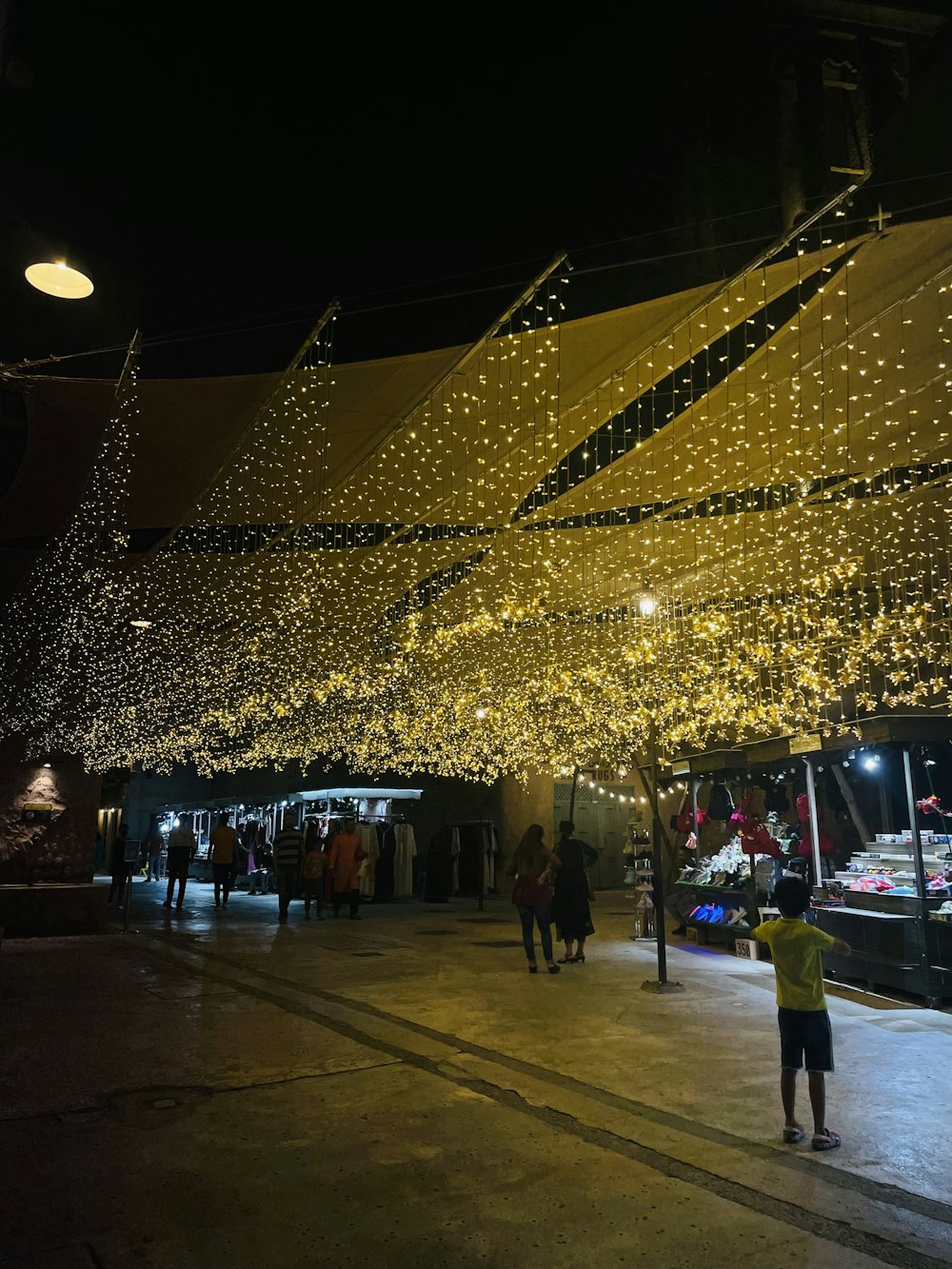 a man standing under a canopy covered in lights