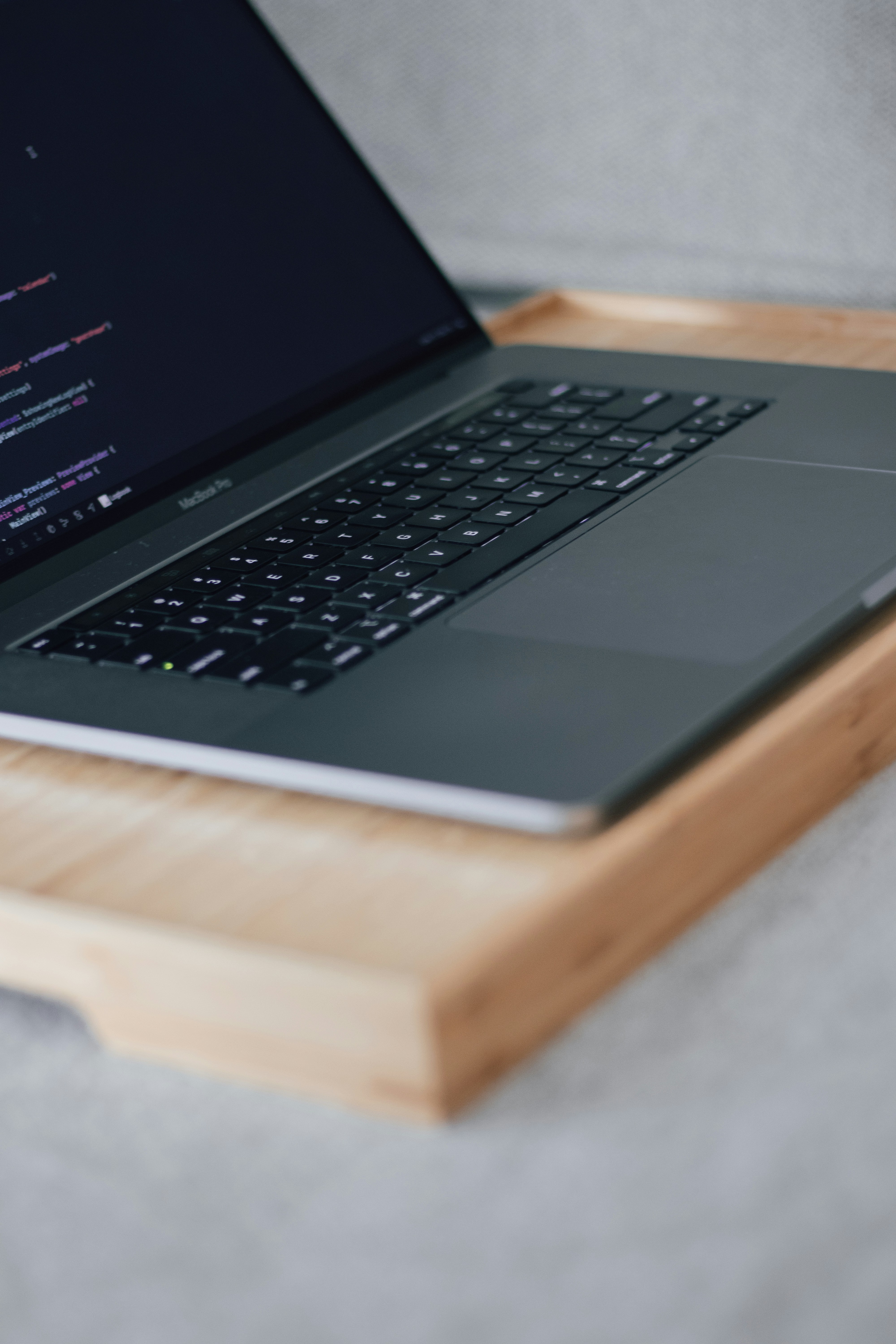 a laptop computer sitting on top of a wooden tray