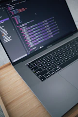 a laptop computer sitting on top of a wooden desk