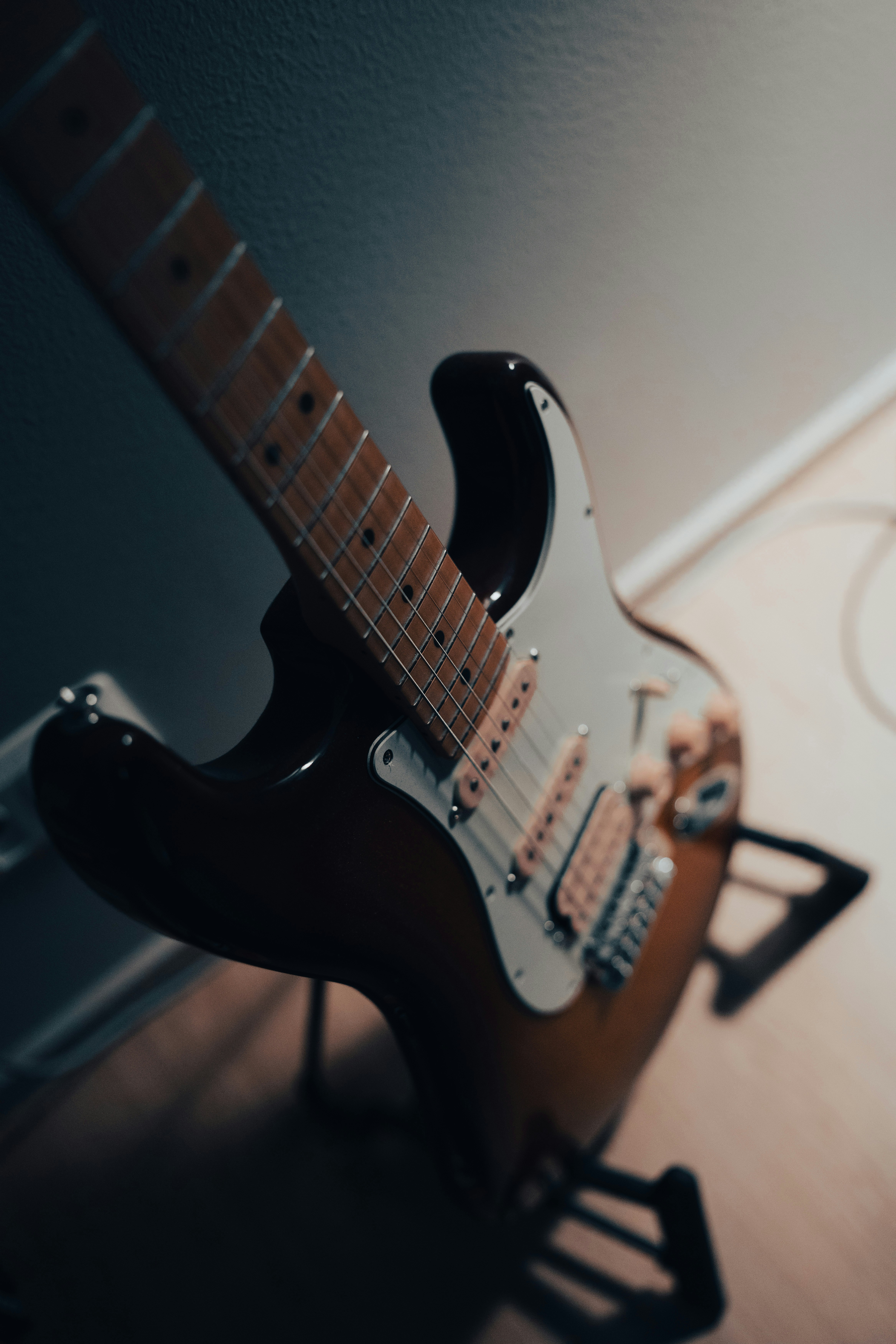 Una guitarra sentada encima de un piso de madera