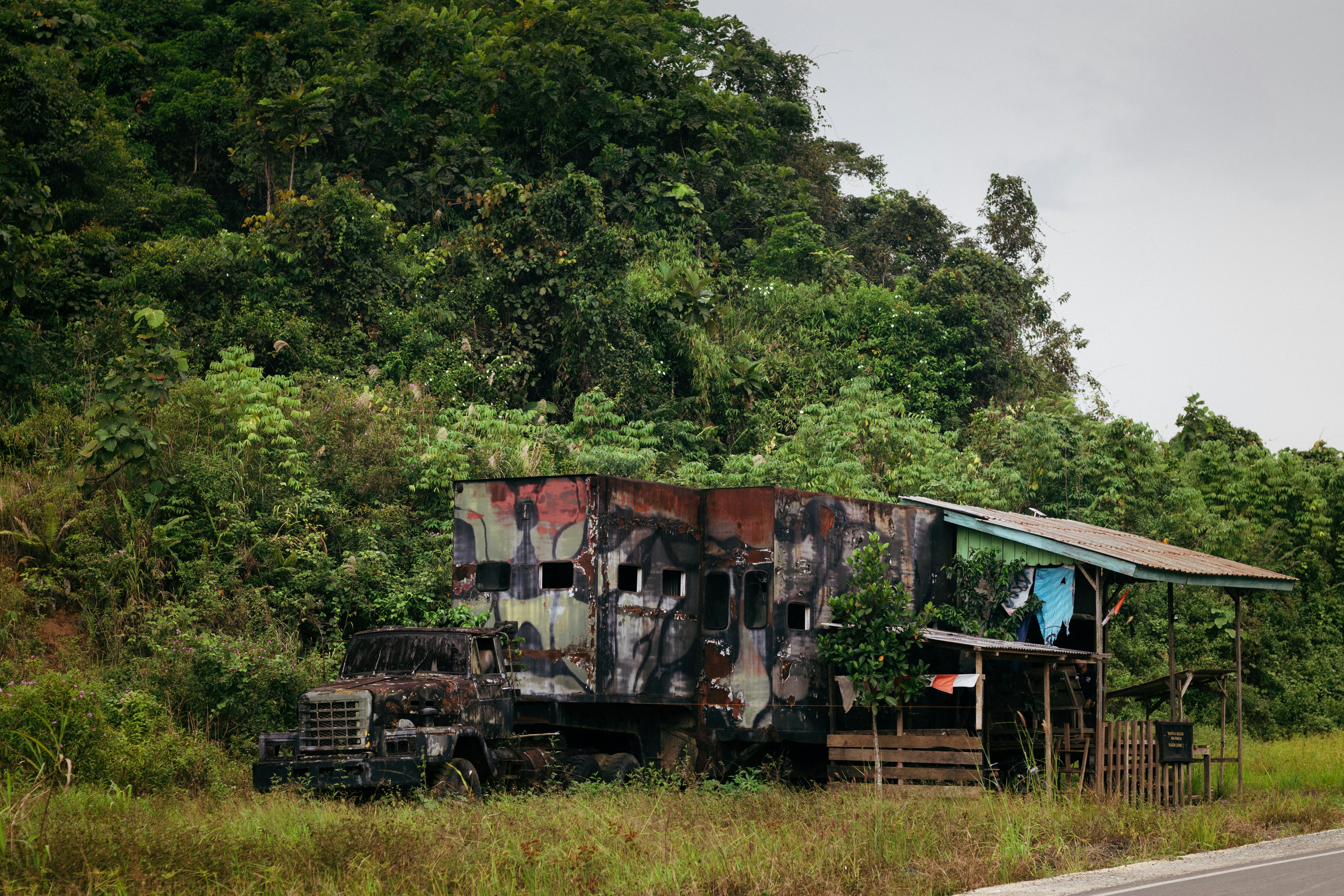 a rusted out truck sitting on the side of a road