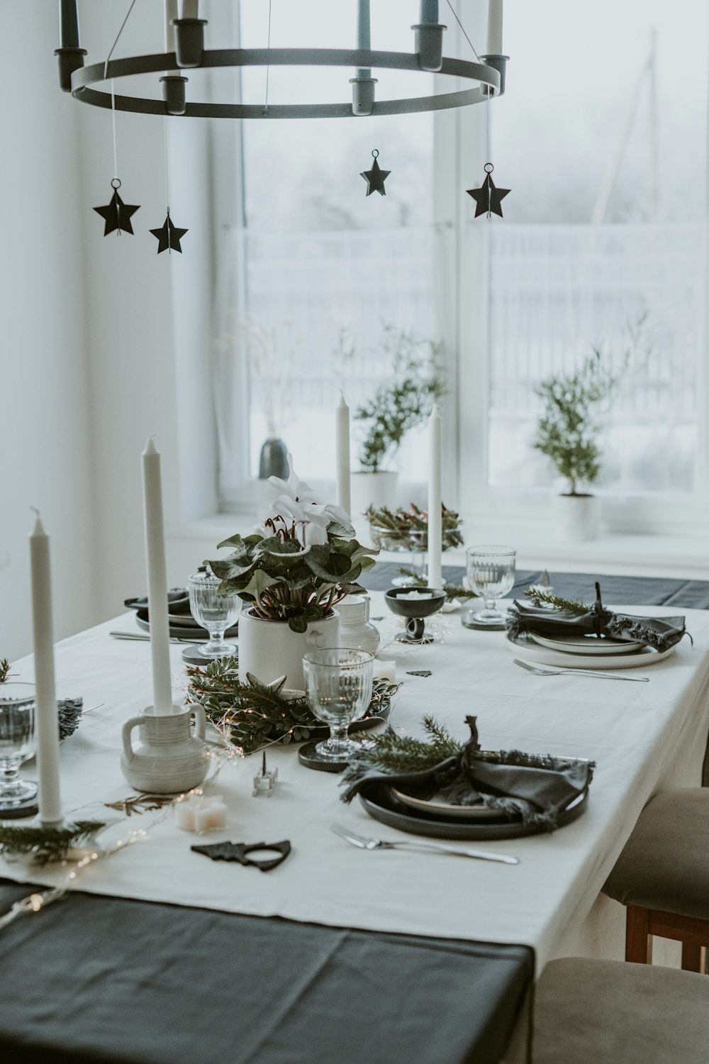 a table with a white table cloth and black place settings