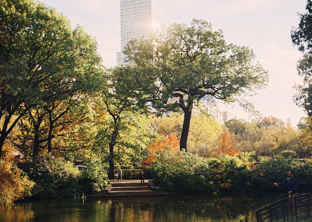 a man is sitting on a bench by the water