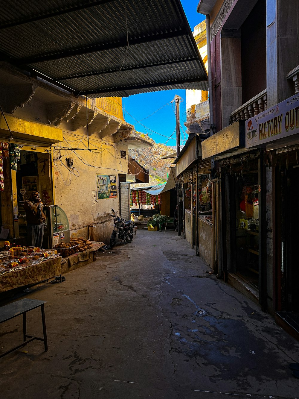 a narrow street with a few shops on both sides