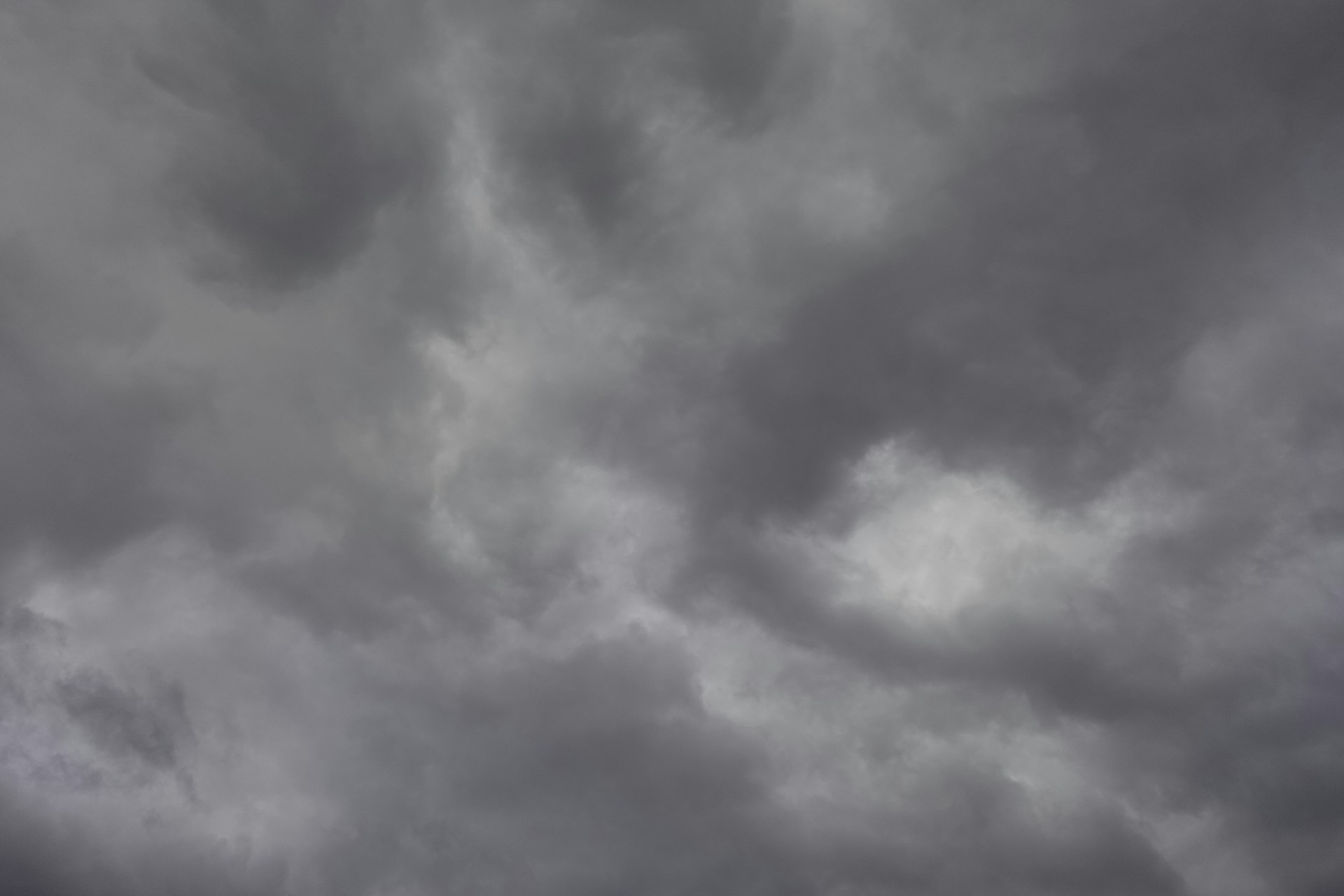a plane flying through a cloudy sky on a cloudy day