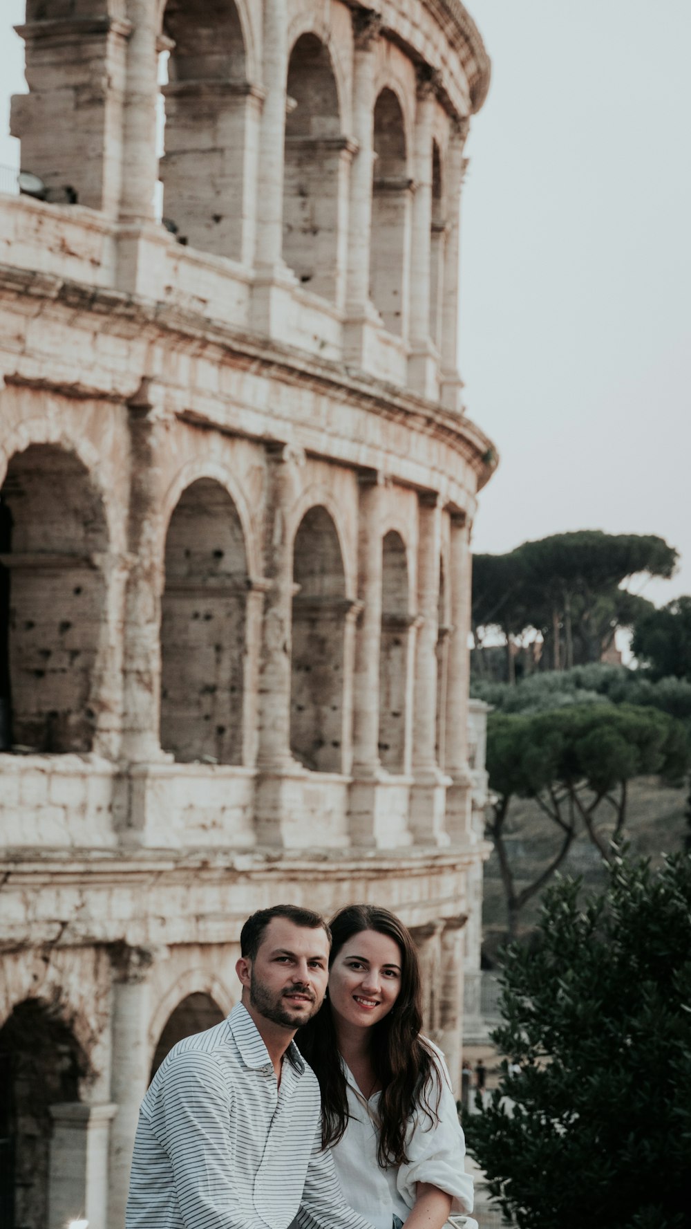 a man and a woman standing in front of an old building