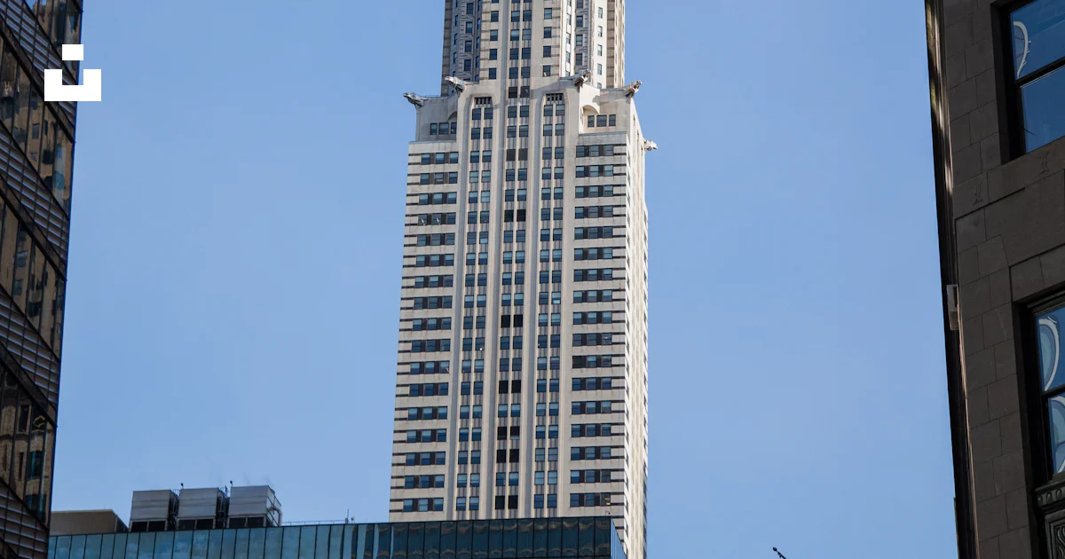 A very tall building towering over a city photo – Free Architecture ...