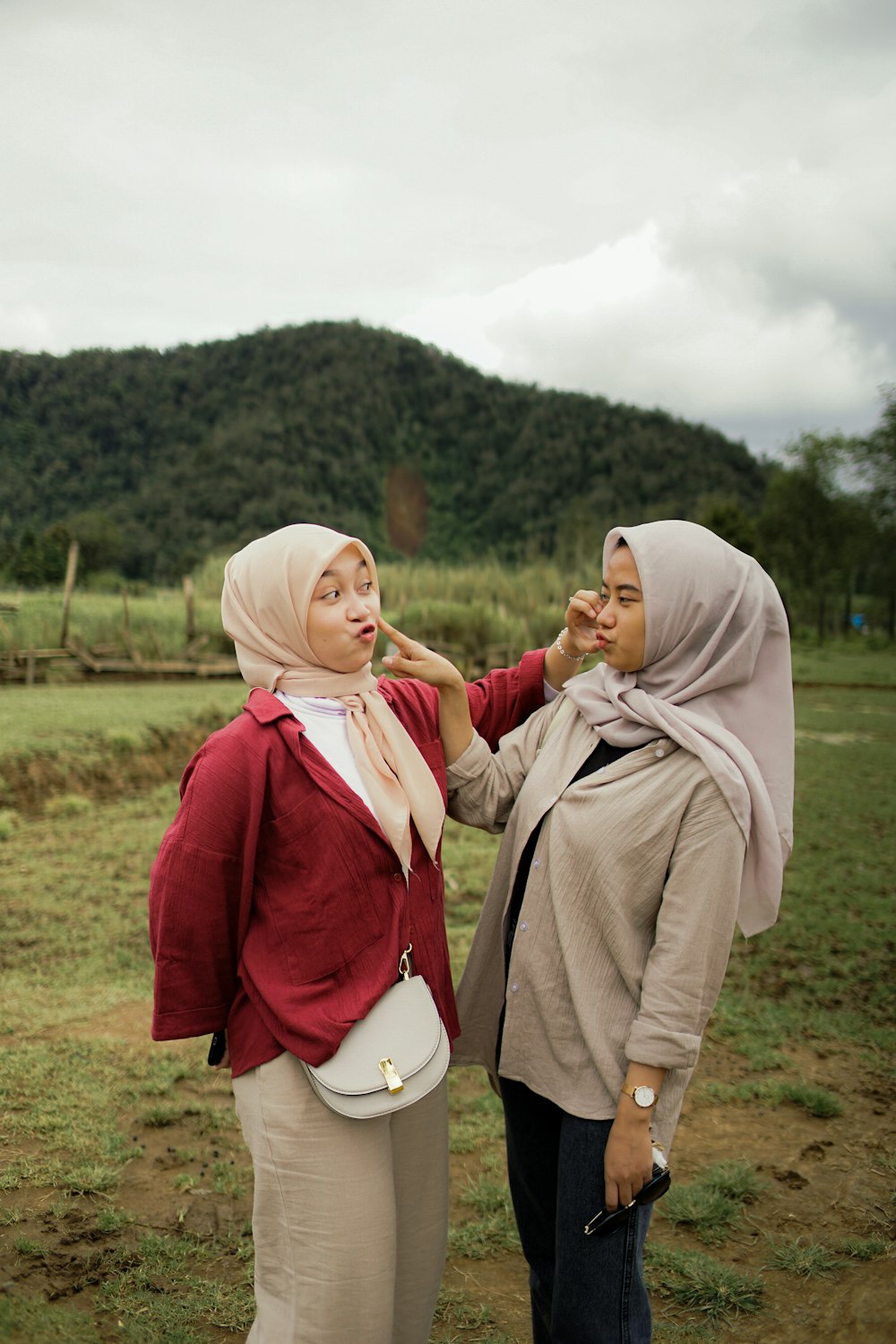 two women standing next to each other in a field