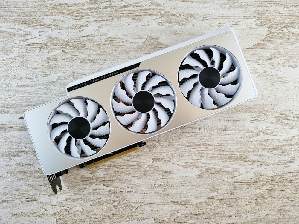 a white and black fan sitting on top of a wooden table