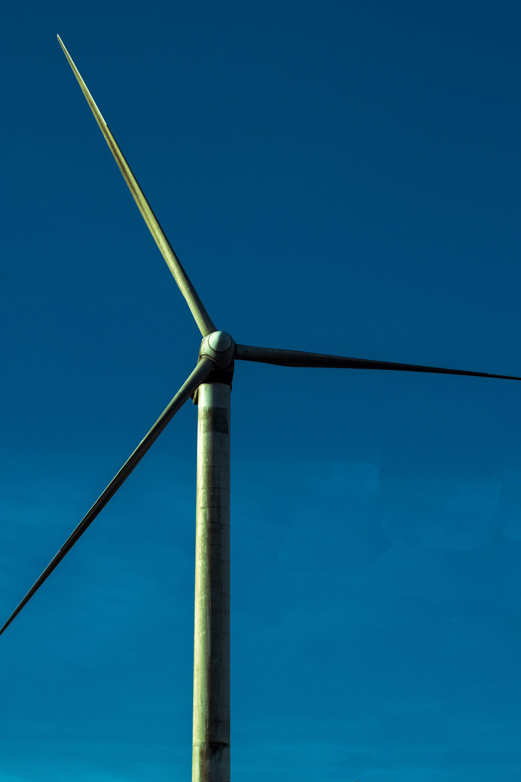 A wind turbine with a blue sky in the background