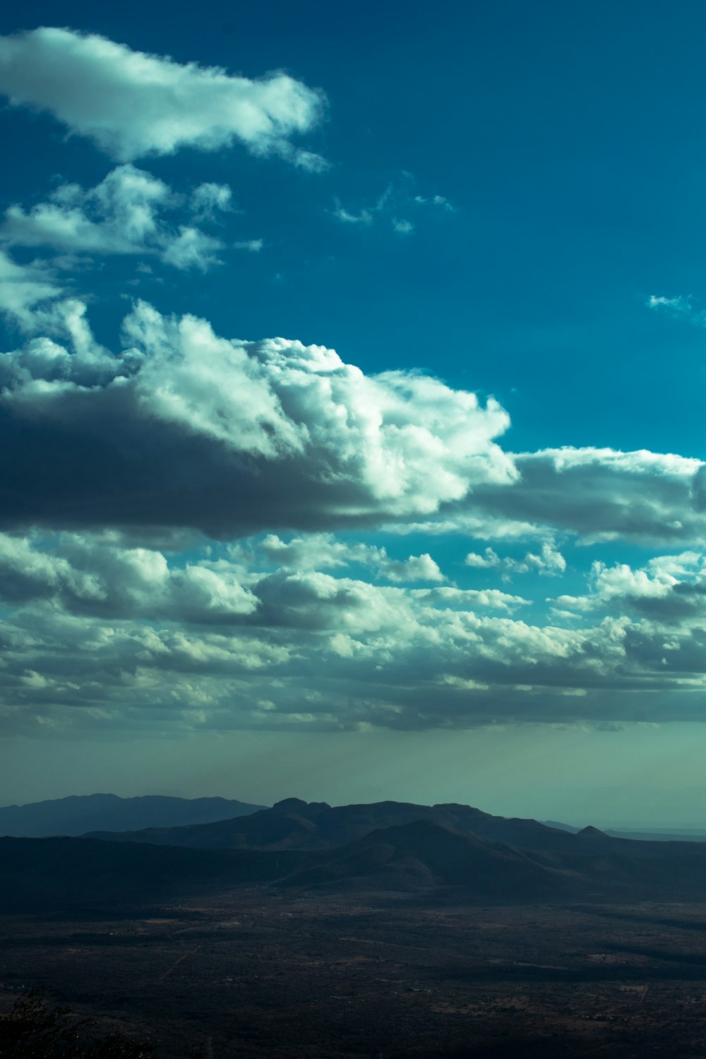 a view of a mountain range with clouds in the sky