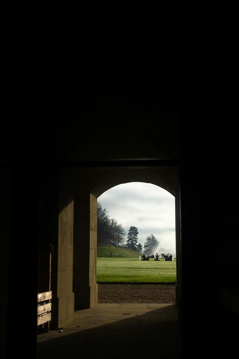 a view of a grassy field through an archway