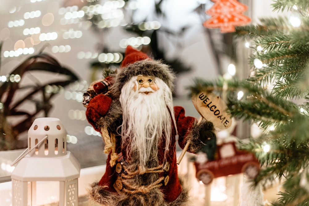 Una figura de Santa Claus junto a un árbol de Navidad