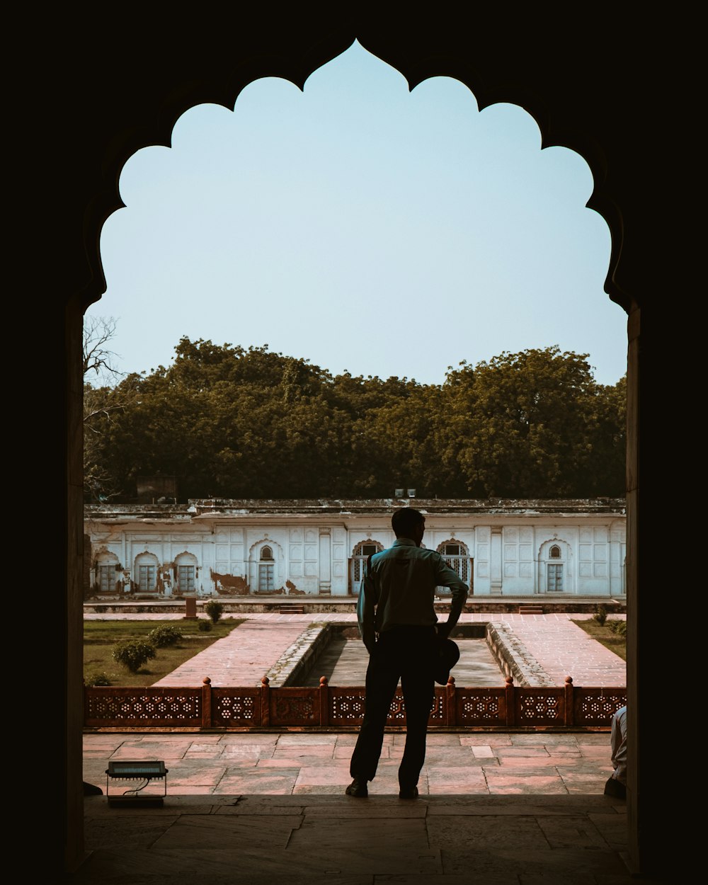 a man standing in a doorway looking at a garden