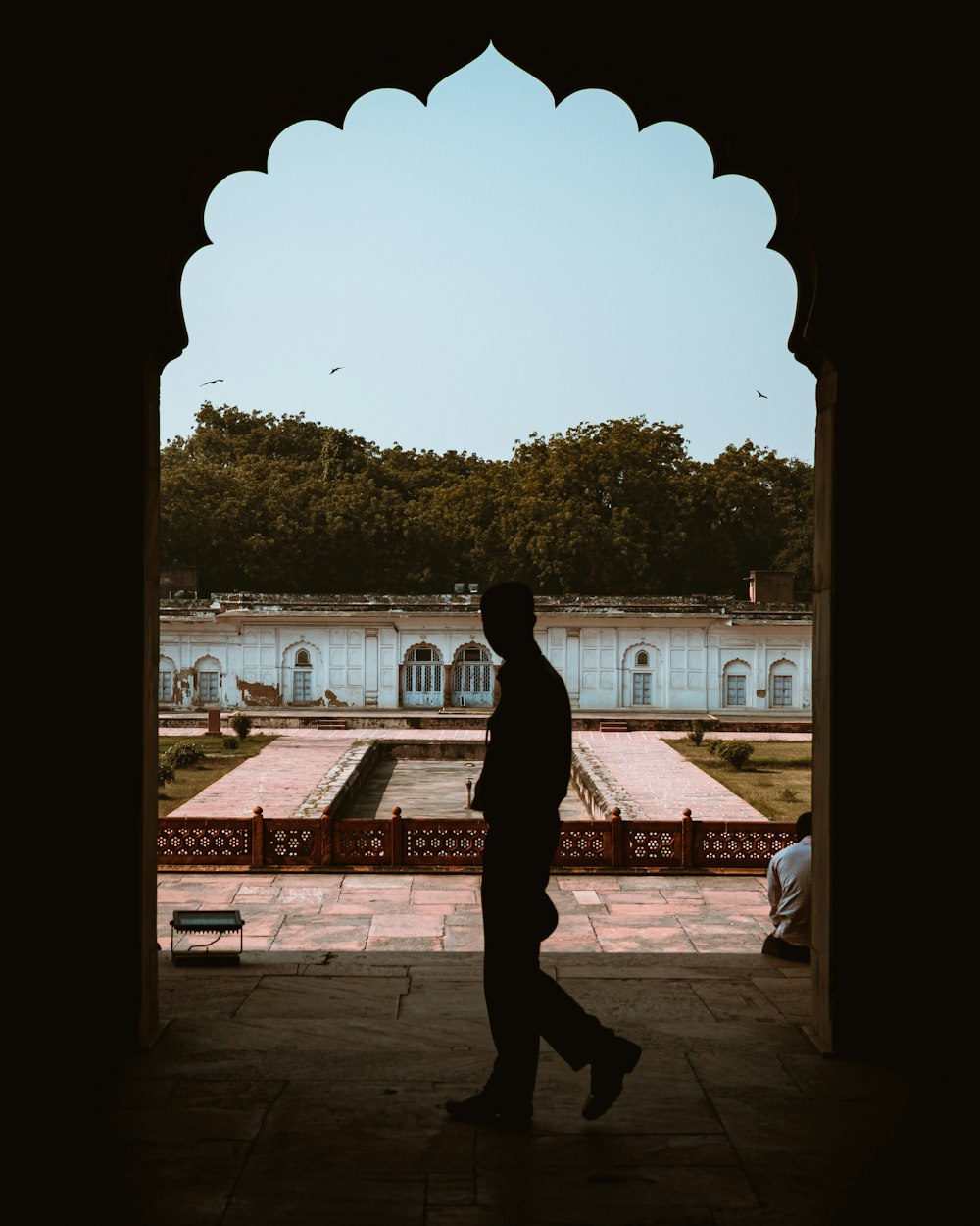 a man walking through an archway in a building