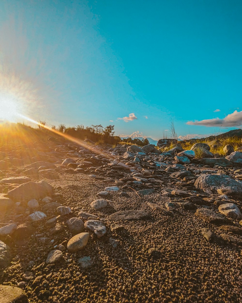 the sun shines brightly over a rocky area