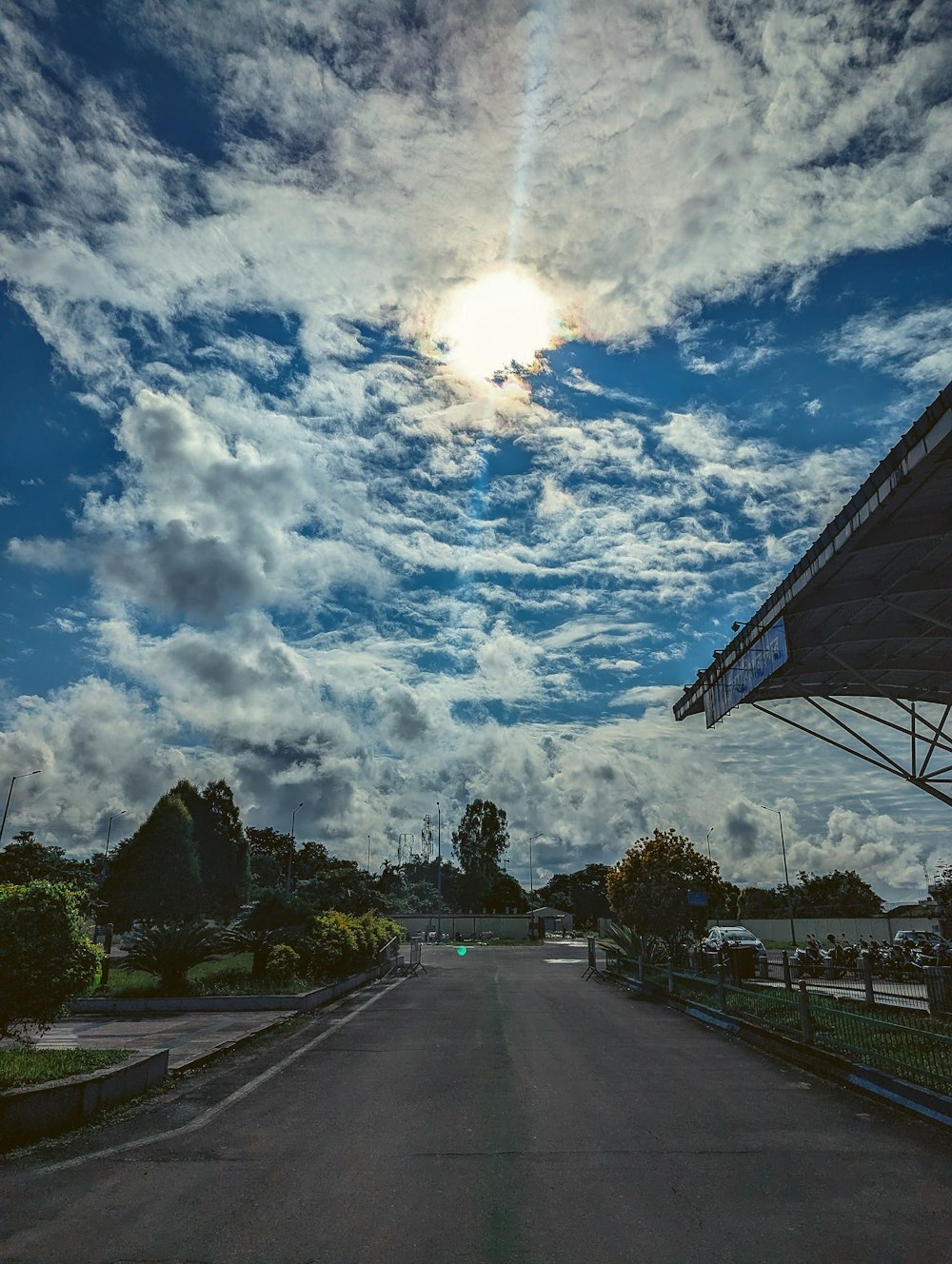 the sun is shining through the clouds over the road