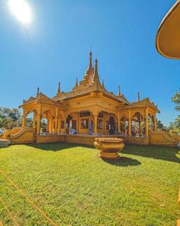 a large yellow building sitting on top of a lush green field