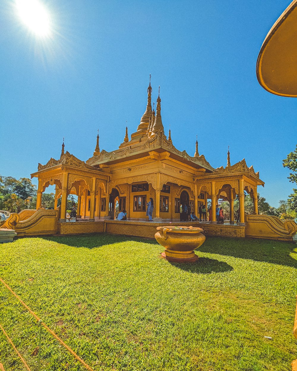 a large yellow building sitting on top of a lush green field