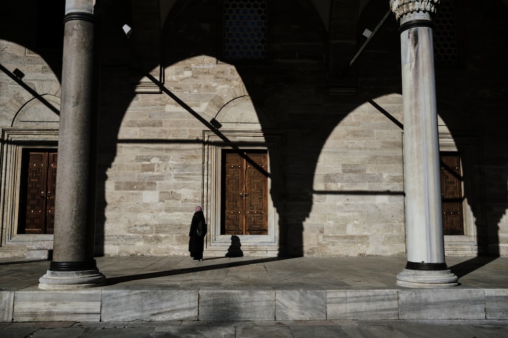 a person standing in a large building with columns