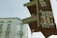 A close-up view of a traffic light covered with various stickers, including ones with the phrases 'Berlin Loves You' and 'Eisern Union.' The background shows the facade of a historical building, slightly out of focus.
