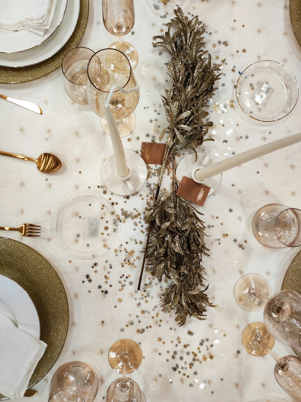 a table is set with white and gold plates and silverware