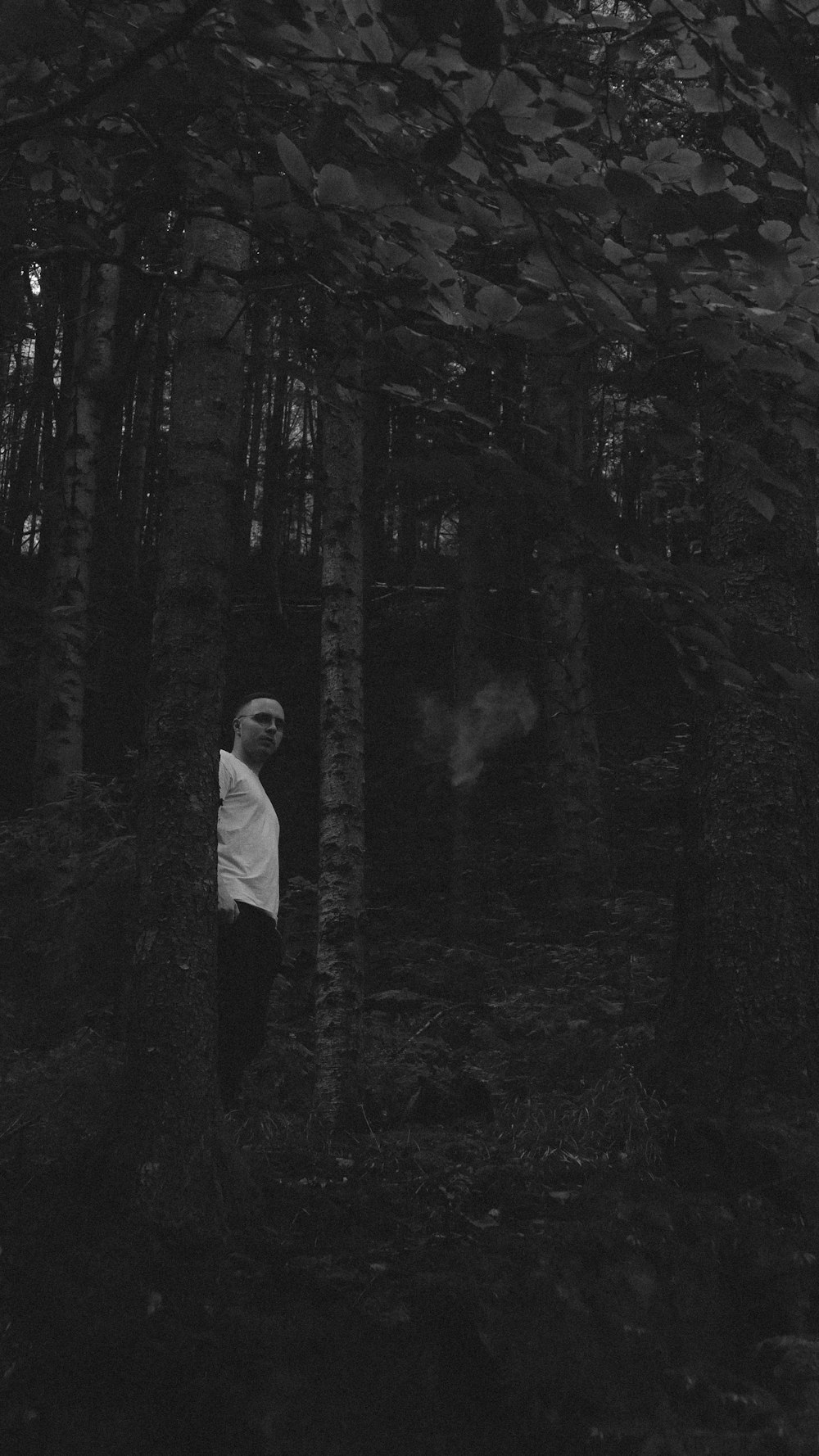 a man standing in the middle of a forest