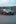a grey car parked in front of a shipping container