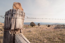 a wooden fence with a barbed wire on top of it
