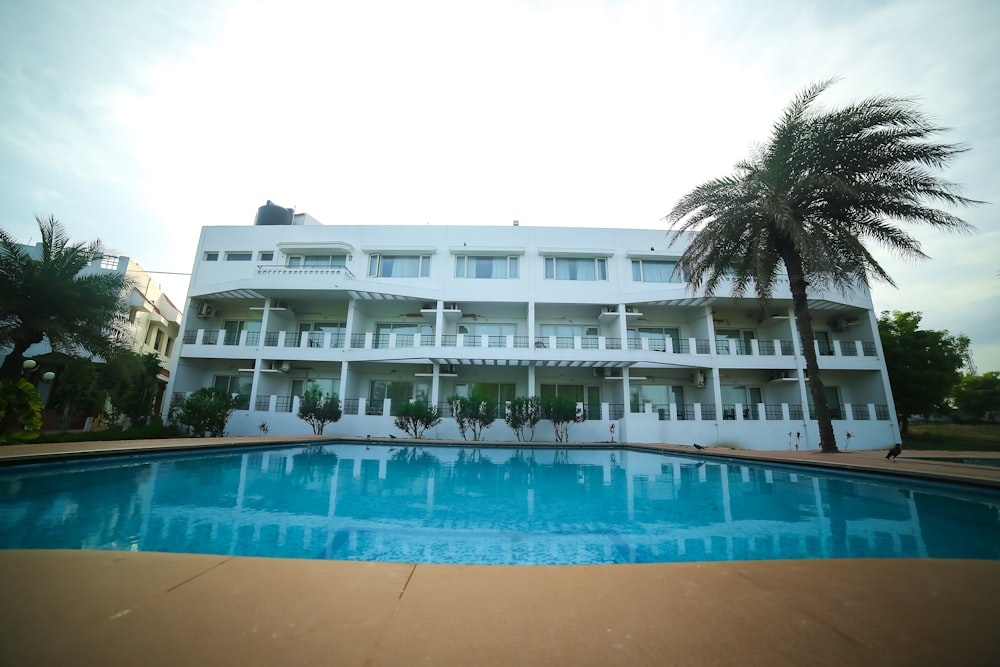 a large white building with a pool in front of it