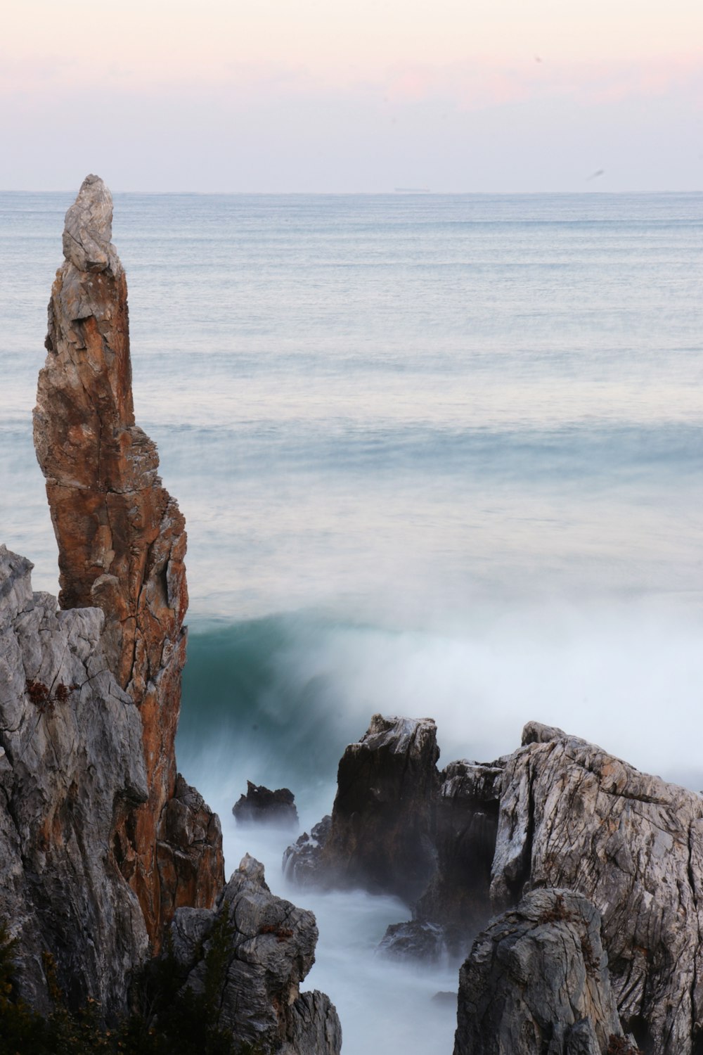 a large rock sticking out of the ocean