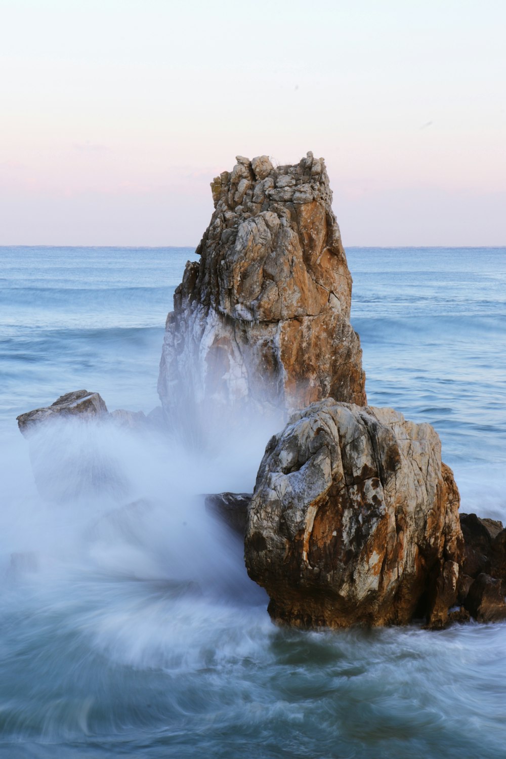 a large rock sticking out of the ocean