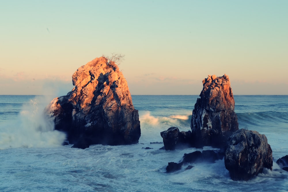 a large rock sticking out of the ocean