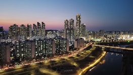 A city skyline at dusk with digital data streams overlay representing connected industries.